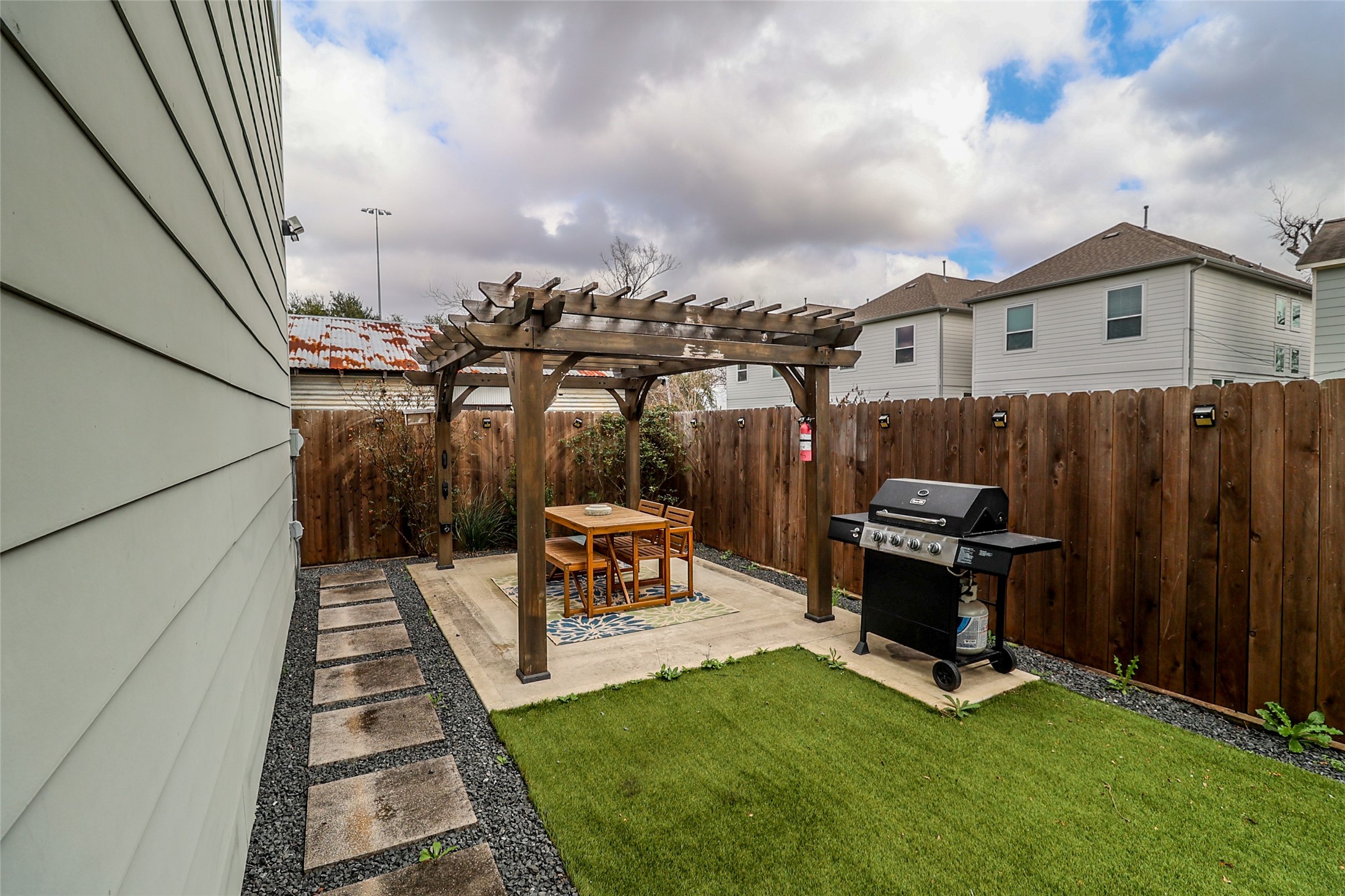 2306 Wipprecht Street Houston, TX 77020 - Photo 25 of 29 a view of a patio with table and chairs a barbeque with wooden fence and roof