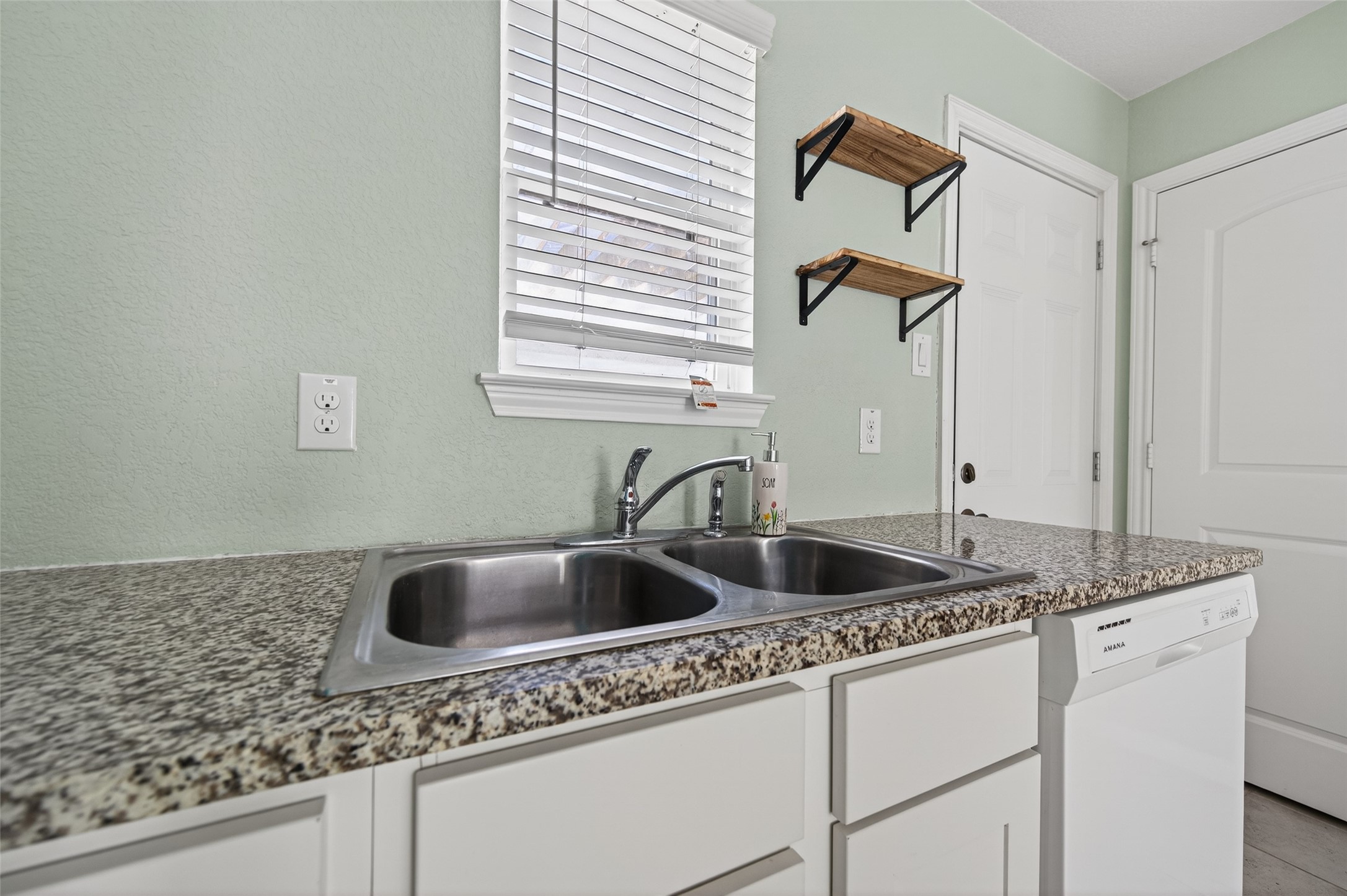 15149 Austin Road Willis, TX 77378 - Photo 14 of 31 a kitchen with a granite countertop sink and cabinets