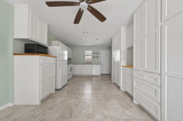 a kitchen with white cabinets and white appliances
