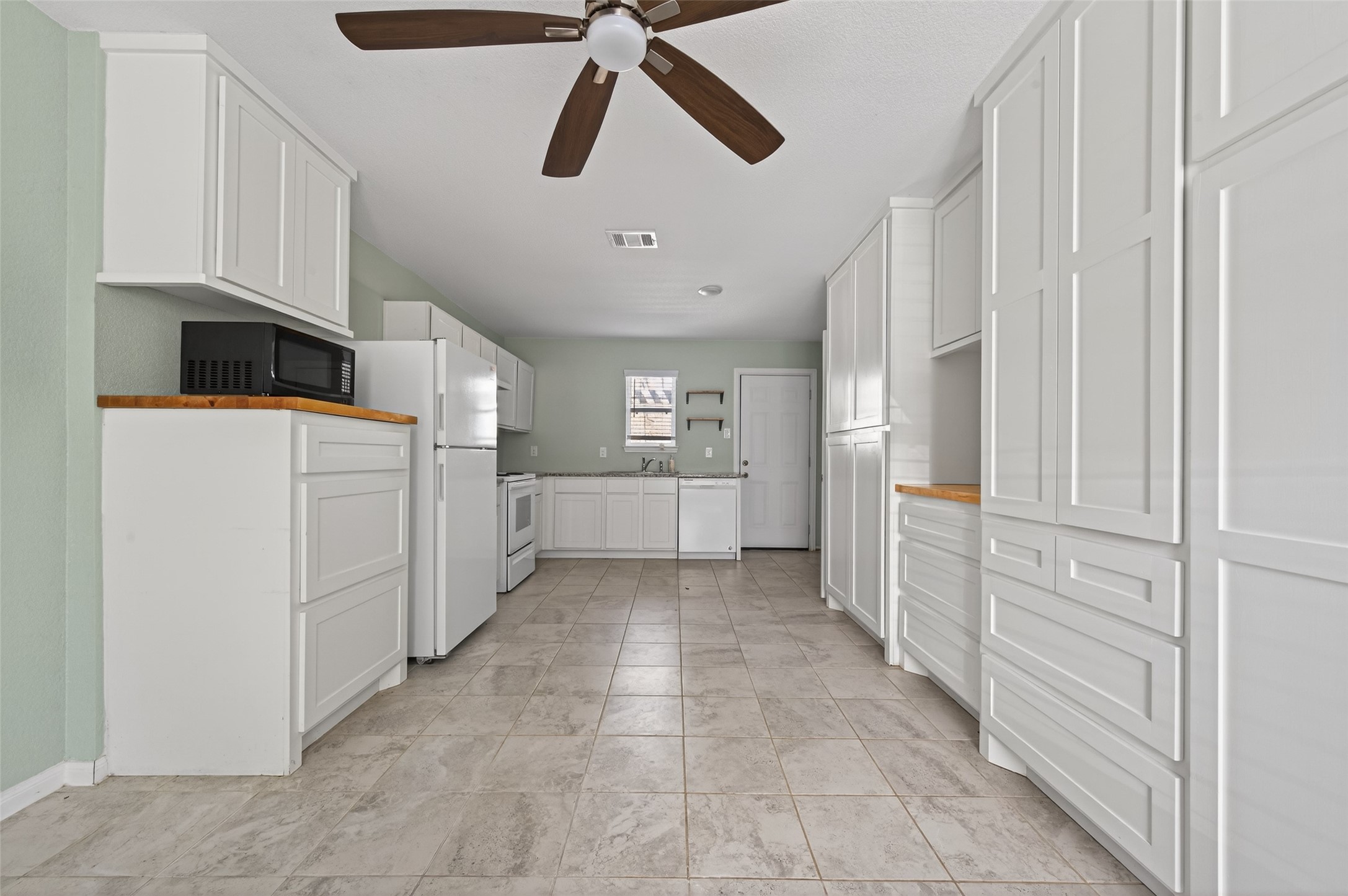 15149 Austin Road Willis, TX 77378 - Photo 8 of 31 a kitchen with white cabinets and white appliances