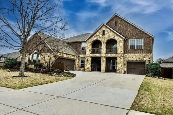 a front view of a house with yard and parking
