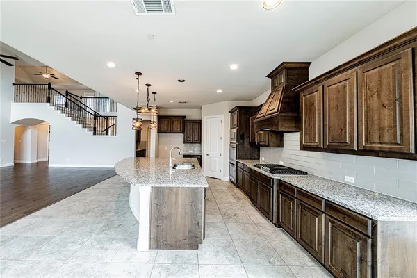 a kitchen with granite countertop a stove and cabinets