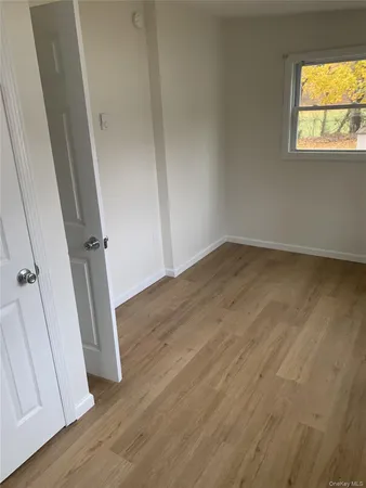 an empty room with wooden floor and a window