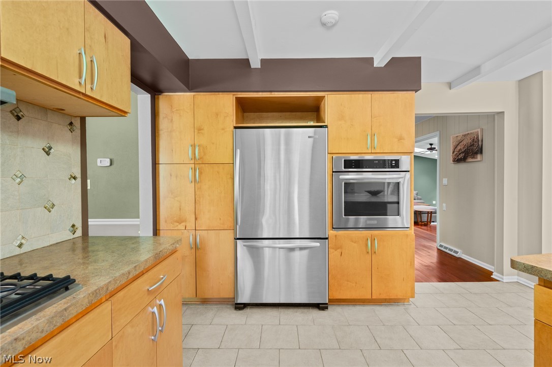 4830 Som Center Road Moreland Hills, OH 44022 - Photo 19 of 48 A perfect kitchen built for the way you cook and gather: stainless steel appliances, a gas stovetop, built-in ovens, and a breakfast island offer everyday function, all beneath warm, beamed ceilings.