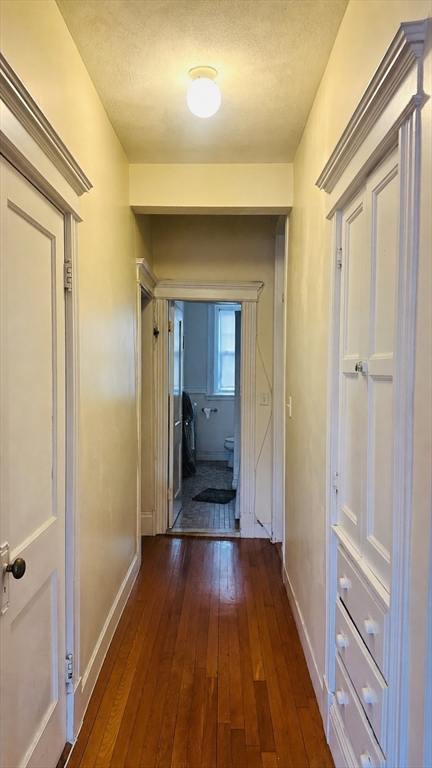 57 Alton Place, Unit 3 Brookline, MA 02446 - Photo 11 of 13 a view of a hallway with wooden floor and a bathroom