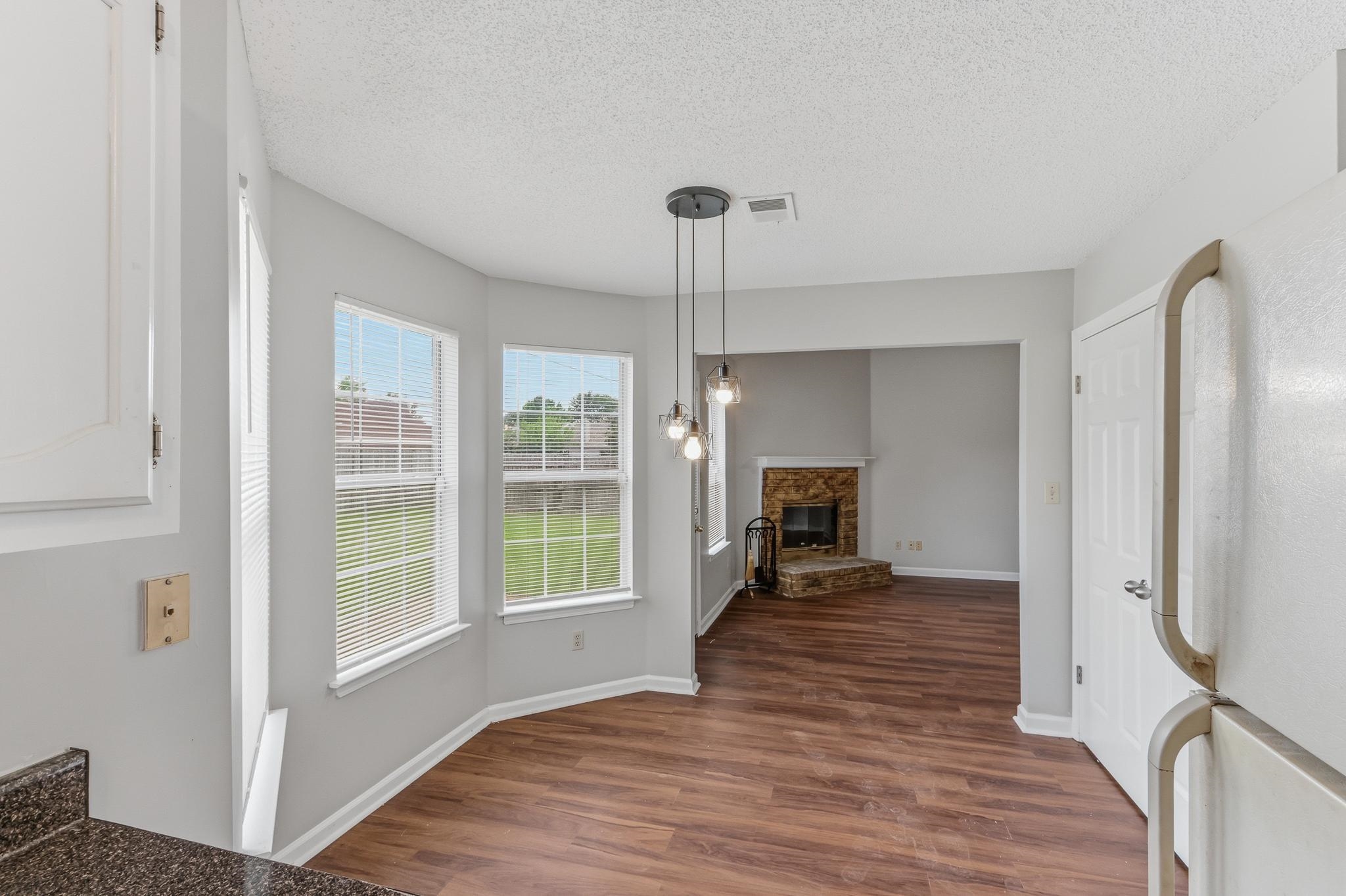 4101 Long Creek Road Memphis, TN 38125 - Photo 2 of 36 Dining area with bay windows, wood-finish flooring, and pendant lighting