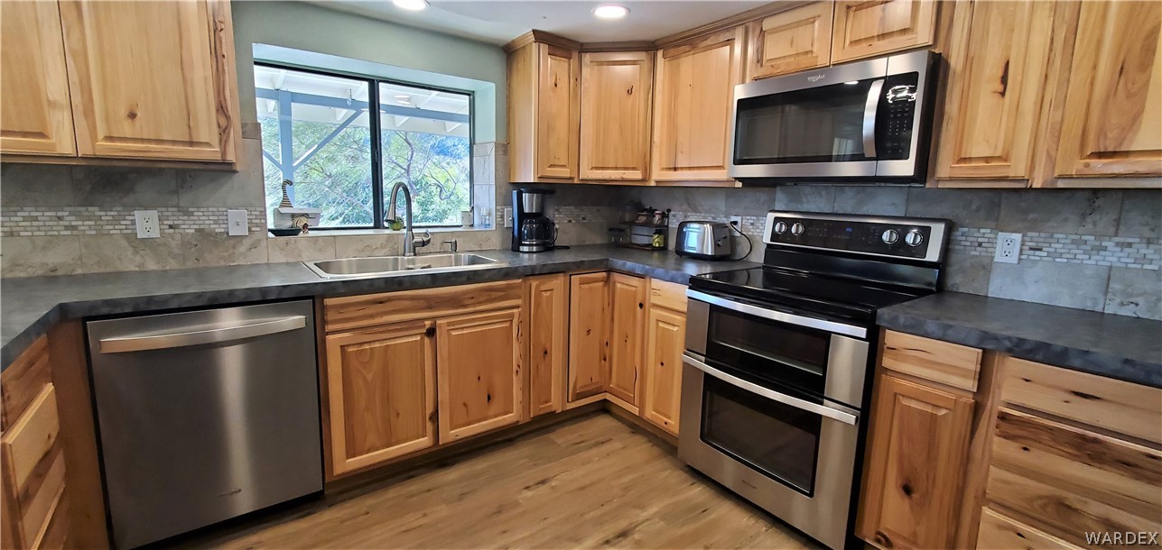 2194 Dewey Road Golden Valley, AZ 86413 - Photo 40 of 95 a kitchen with stainless steel appliances granite countertop a sink a stove and a microwave