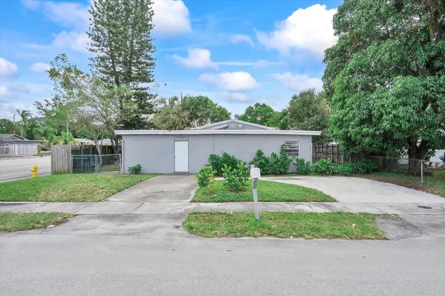 a view of a house with a yard and large tree