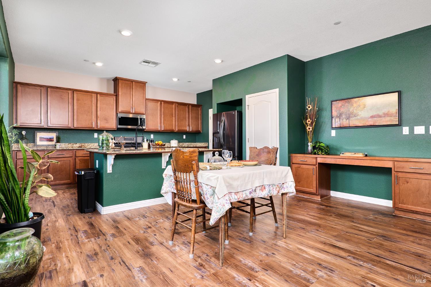 4398 Artisan Path, Unit 724 :2 Rio Vista, CA 94571 - Photo 11 of 24 a kitchen with stainless steel appliances granite countertop a refrigerator a stove top oven a sink with green countertops and wooden floor
