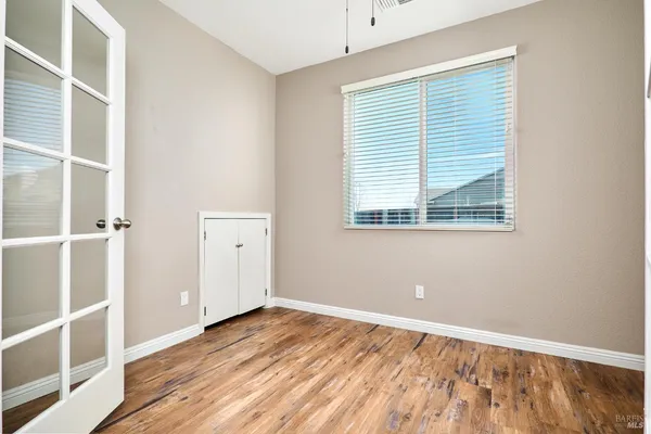 an empty room with a window and wooden floor