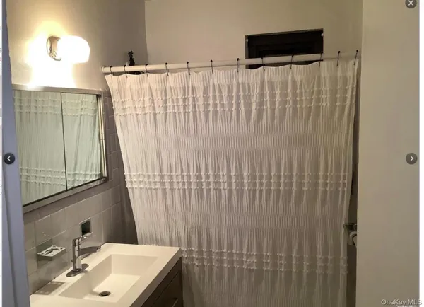 a bathroom with a sink vanity and a mirror