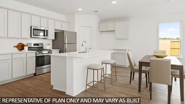 a kitchen with a table chairs microwave and cabinets