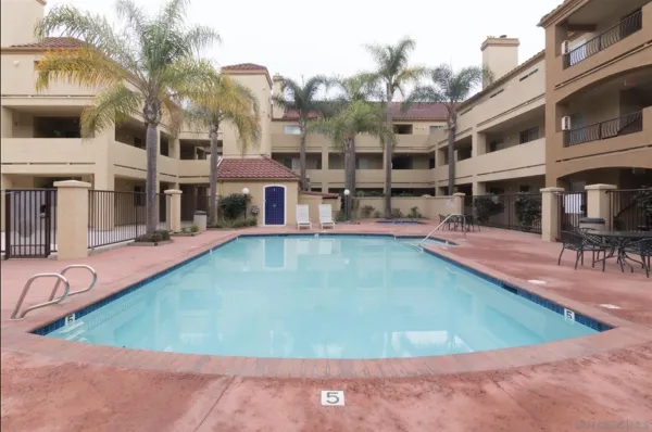 an aerial view of residential houses with outdoor space and parking
