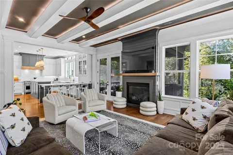 a living room with furniture fireplace and a large window