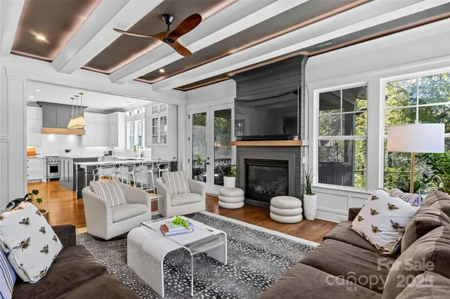 a living room with furniture fireplace and a large window