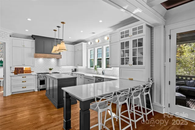 a kitchen with stainless steel appliances granite countertop a stove top oven a sink a counter space and cabinets