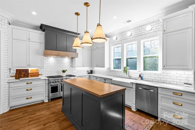 a kitchen with stainless steel appliances granite countertop a sink and a stove