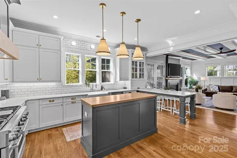 a open kitchen with stainless steel appliances granite countertop a sink a stove and a wooden floors