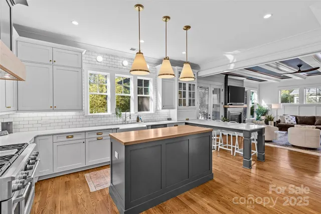 a open kitchen with stainless steel appliances granite countertop a sink a stove and a wooden floors