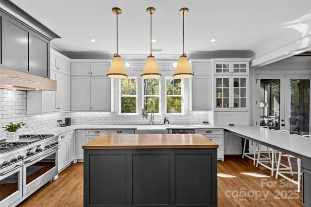 a kitchen with stainless steel appliances granite countertop a sink stove and cabinets