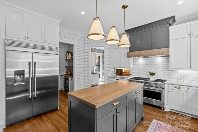 a kitchen with stainless steel appliances granite countertop a sink a stove and a refrigerator