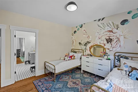 a bedroom with a baby bed a couch and a dresser