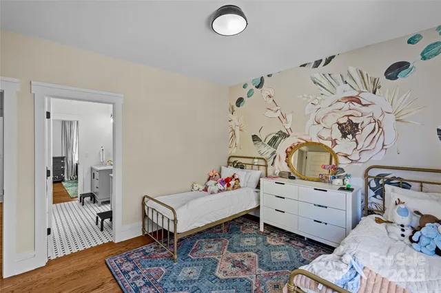 a bedroom with a baby bed a couch and a dresser