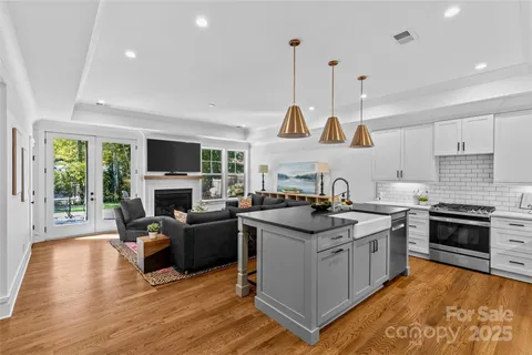a kitchen with stainless steel appliances a dining table chairs and a refrigerator
