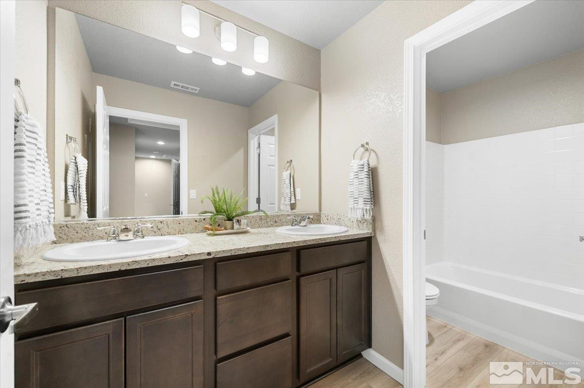 1180 Arrastra Road, Unit LOT 15 Reno, NV 89512 - Photo 30 of 34 a bathroom with a double vanity sink and mirror with bathtub