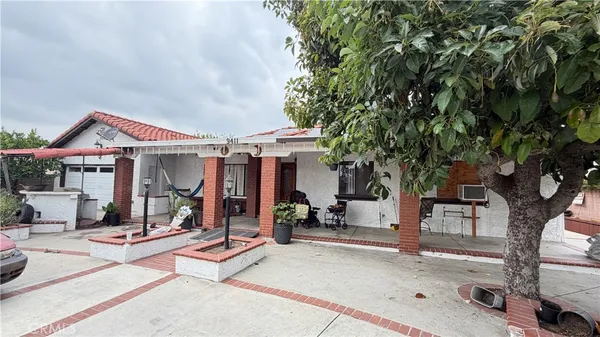 a front view of a house with a tree
