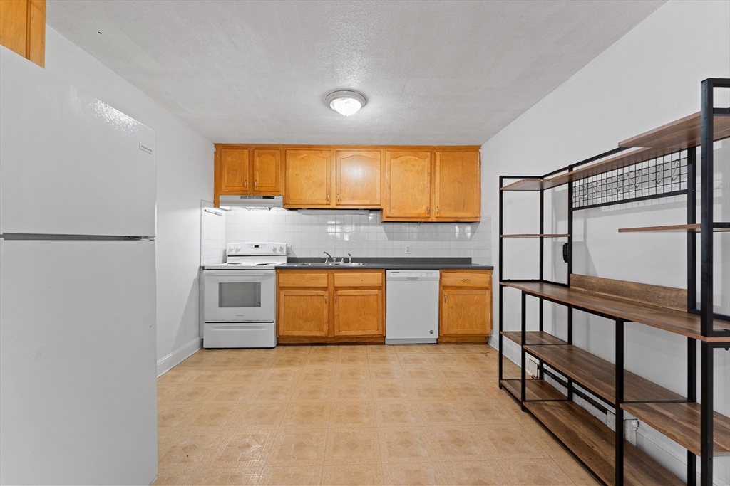 3 Walker Road, Unit 1 North Andover, MA 01845 - Photo 4 of 19 a kitchen with stainless steel appliances granite countertop a sink and a refrigerator