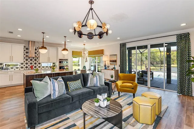 a living room with furniture kitchen view and a large window