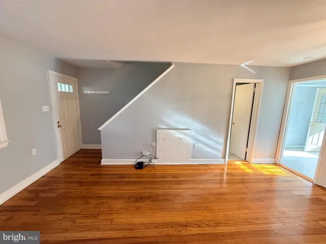 a view of a livingroom with wooden floor and staircase