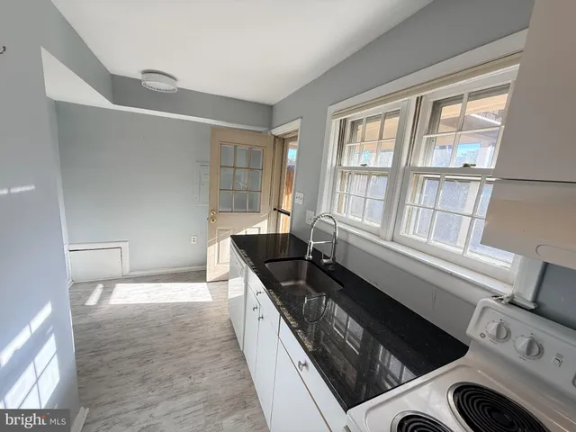 a kitchen with granite countertop a stove and a sink