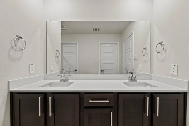 a bathroom with a sink a toilet and a large mirror
