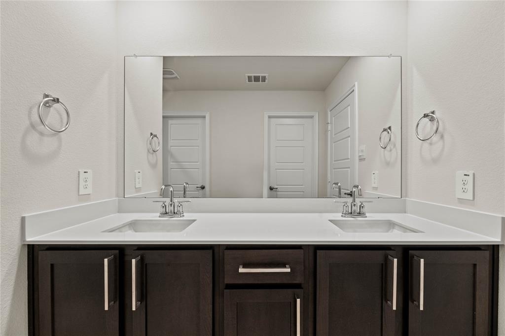 411 Revolution Road Fate, TX 75087 - Photo 11 of 34 a bathroom with a sink and a mirror