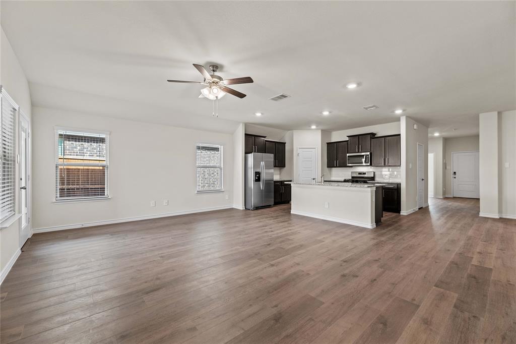 411 Revolution Road Fate, TX 75087 - Photo 22 of 34 a view of a kitchen with a sink a refrigerator and a stove top oven