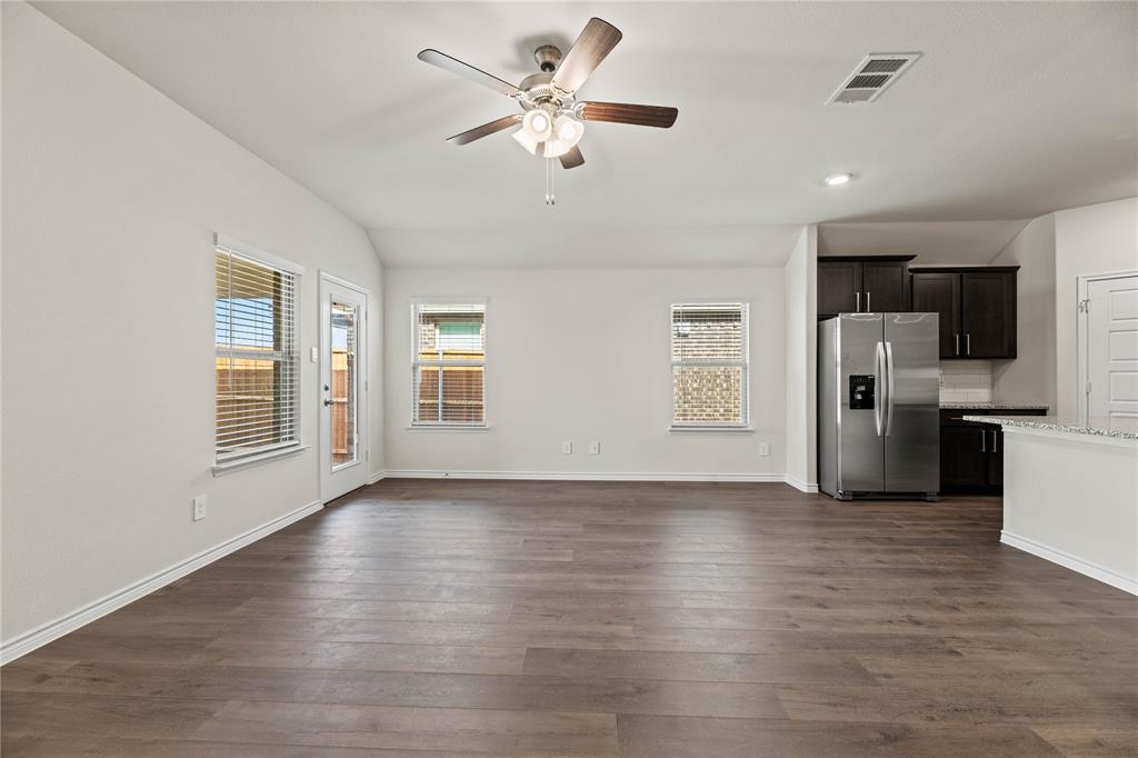 411 Revolution Road Fate, TX 75087 - Photo 25 of 34 a view of a kitchen with refrigerator stove and wooden floor