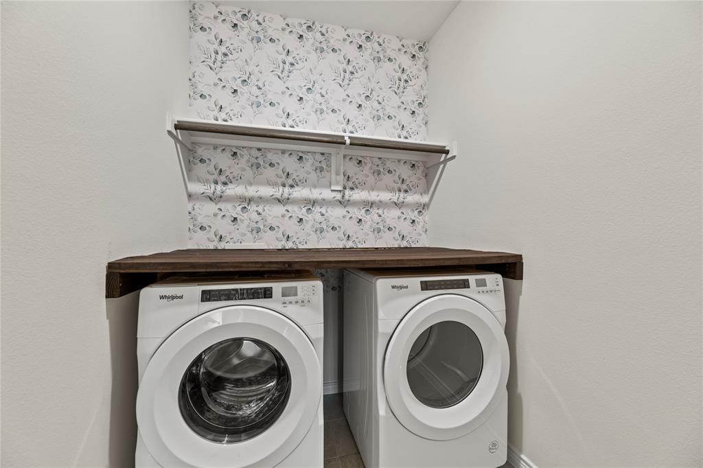 411 Revolution Road Fate, TX 75087 - Photo 3 of 34 a close view of a utility room with dryer and washer