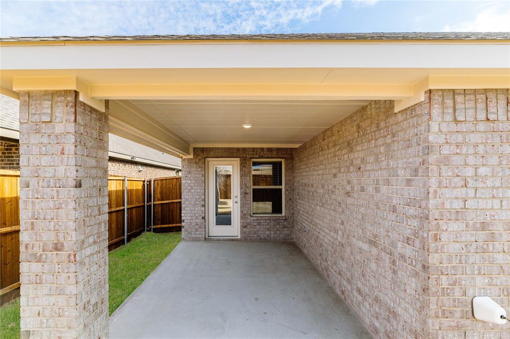 411 Revolution Road Fate, TX 75087 - Photo 32 of 34 a view of a porch with a floor to ceiling window next to a yard