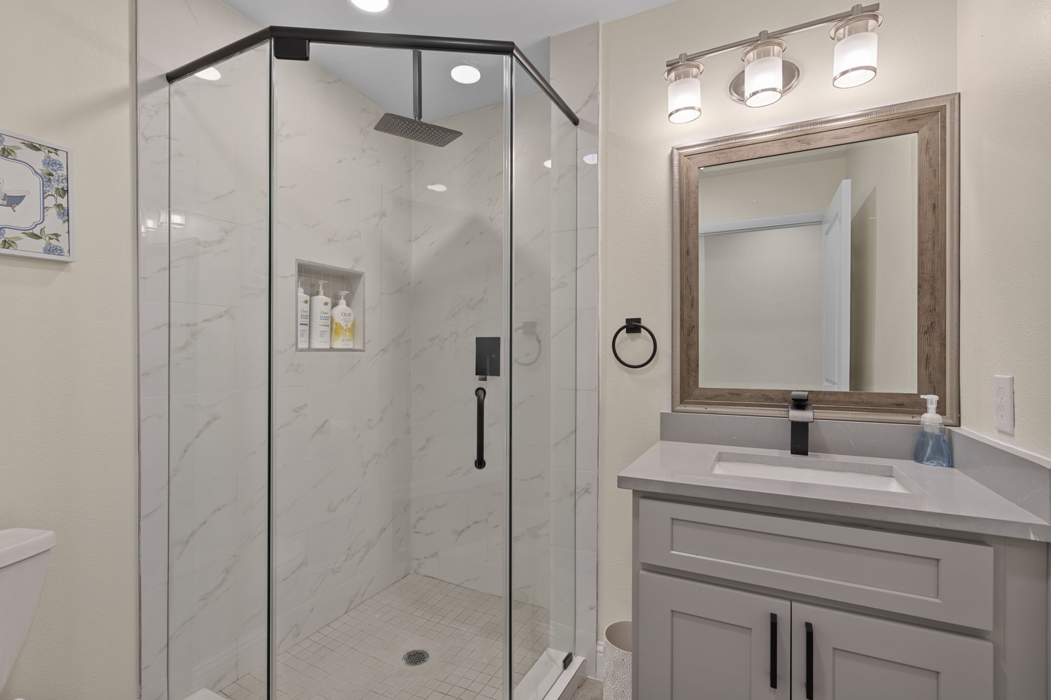 2402 Chimney Rock Road Houston, TX 77057 - Photo 29 of 36 Stylish bathroom featuring a frameless glass walk-in shower, modern tile surround, and a sleek vanity with updated fixtures and ample counter space.