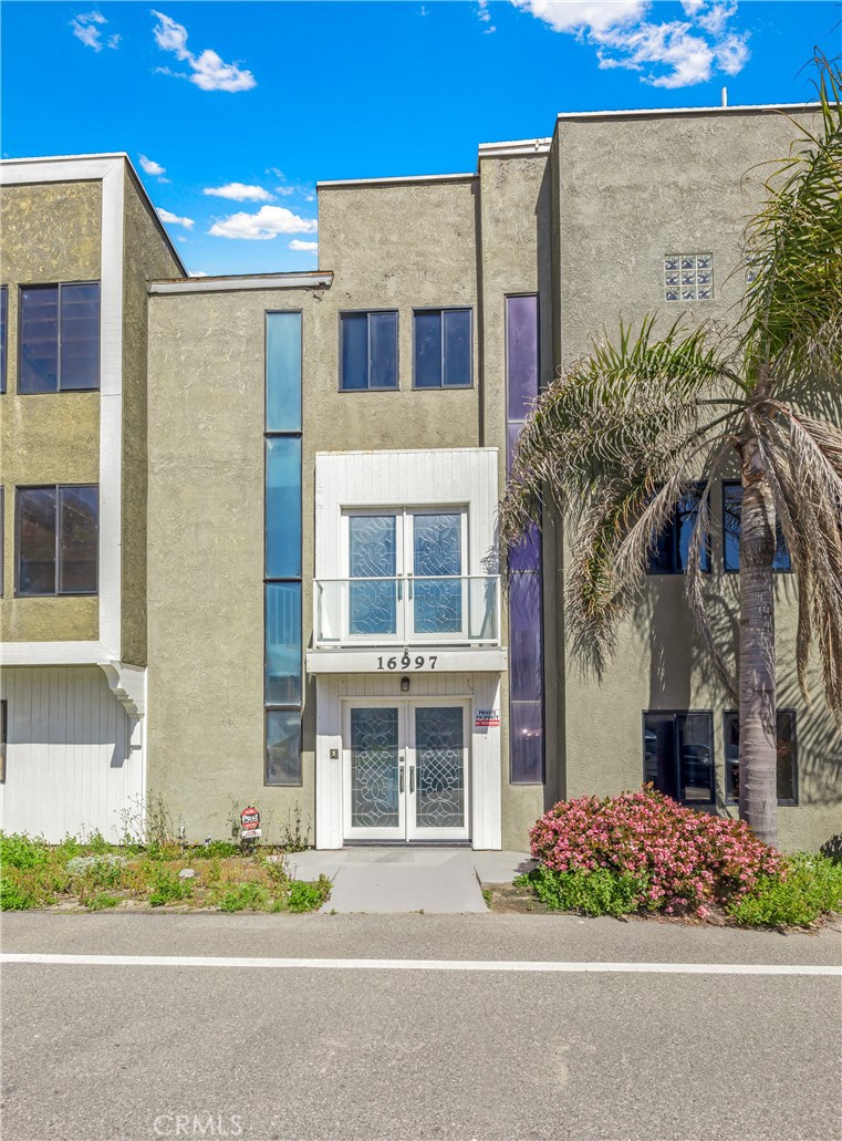 16995 8th Street Sunset Beach, CA 90742 - Photo 38 of 51 a front view of a multi story residential apartment building with a yard and potted plants