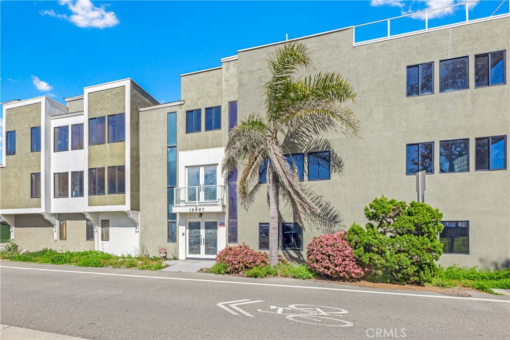 16995 8th Street Sunset Beach, CA 90742 - Photo 40 of 51 a front view of a multi story residential apartment building with yard and flowers