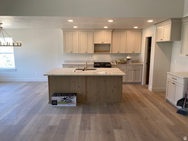 4676 West 75 North, Unit 401 West Point, UT 84015 - Photo 23 of 25 Contemporary kitchen featuring an expansive center island with an integrated sink and gooseneck faucet