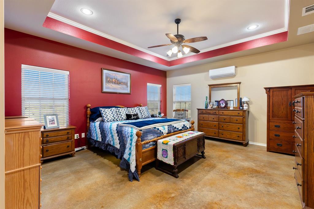 3794 County Road 1089 Celeste, TX 75423 - Photo 13 of 40 a spacious bedroom with a bed and a chandelier