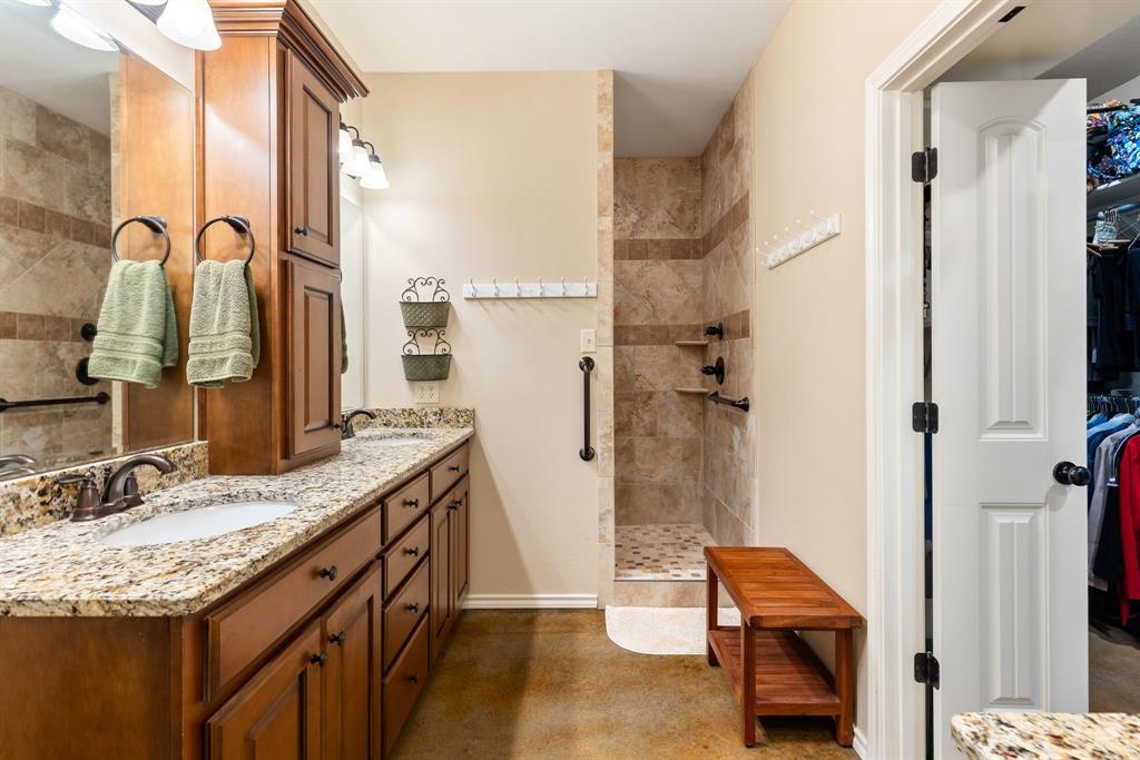 3794 County Road 1089 Celeste, TX 75423 - Photo 18 of 40 a bathroom with a granite countertop sink a mirror and a shower