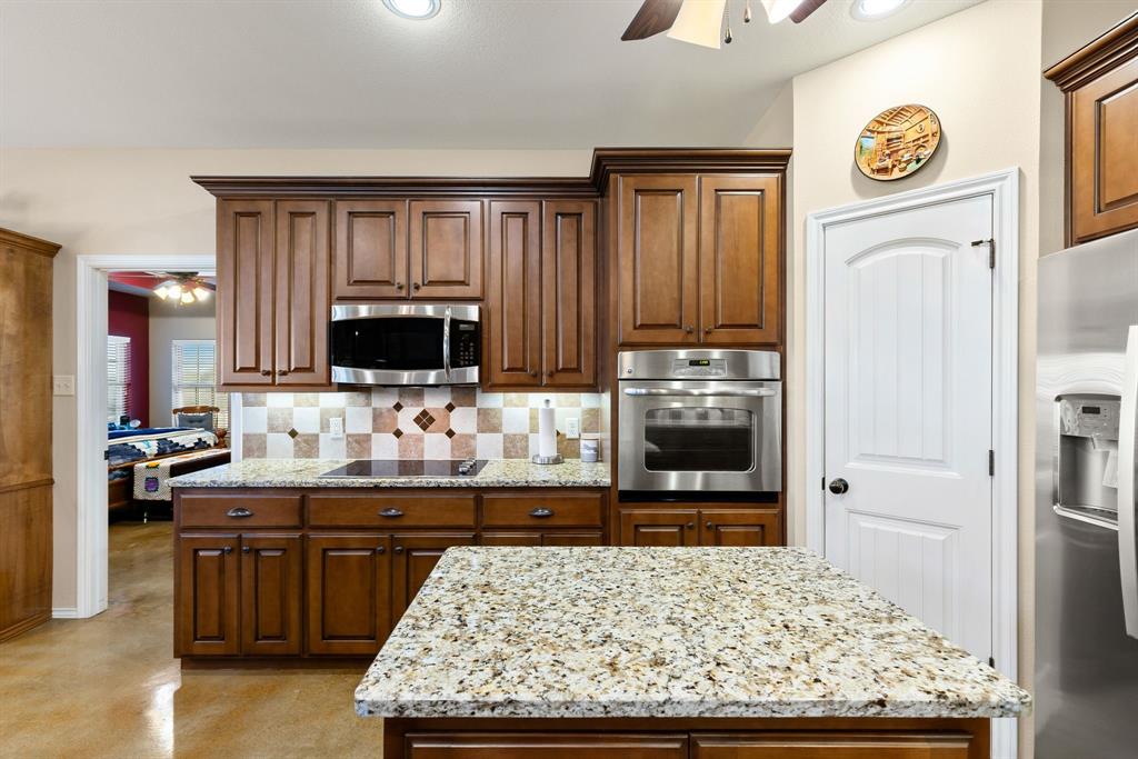 3794 County Road 1089 Celeste, TX 75423 - Photo 9 of 40 Kitchen featuring ceiling fan, stainless steel appliances, and light stone countertops