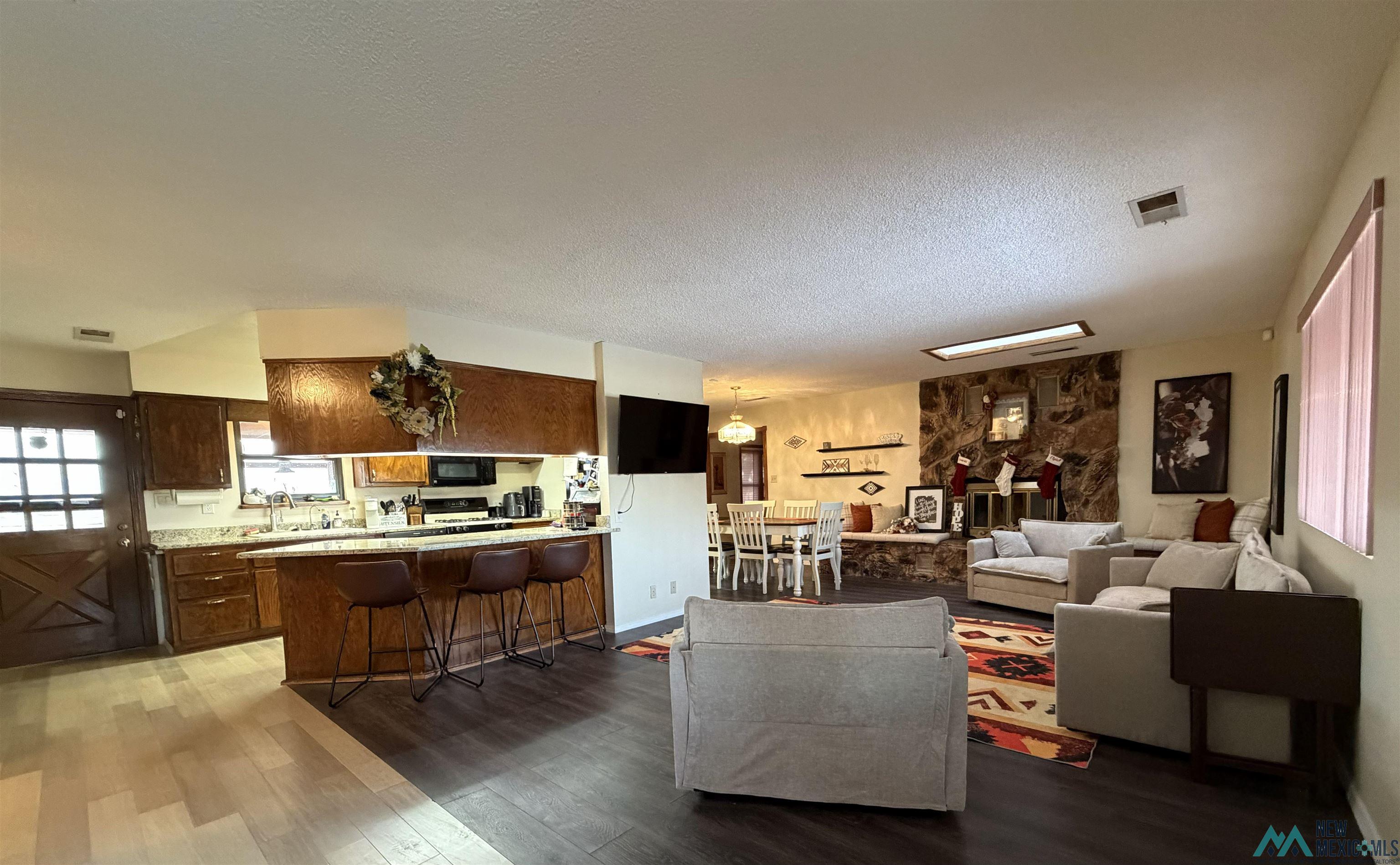 2001 East Derrick Road Carlsbad, NM 88220 - Photo 45 of 84 Living area with plenty of natural light, a textured ceiling, and light wood finished floors