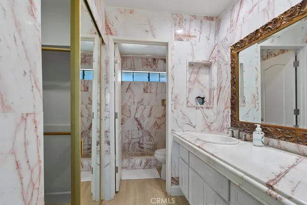 a bedroom with a bed and a lamp on dresser