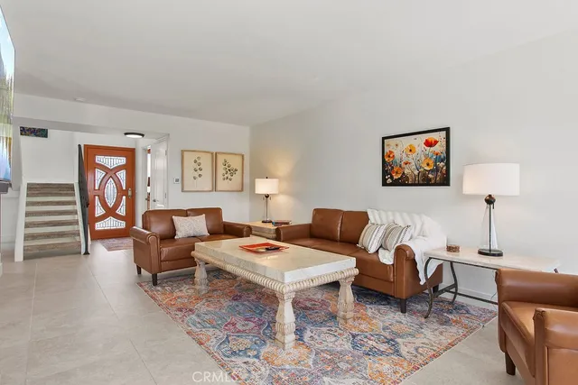 a living room with furniture a rug and a window